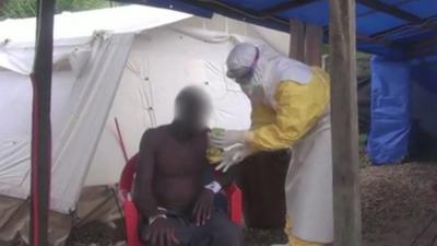 Man is treated by person in contamination suit