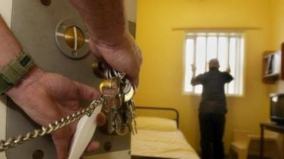 Guard locks prison cell door