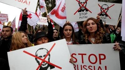 Supporters of the United National Movement Party hold anti-Putin placards during an anti-Russia rally, Tbilisi, Georgia