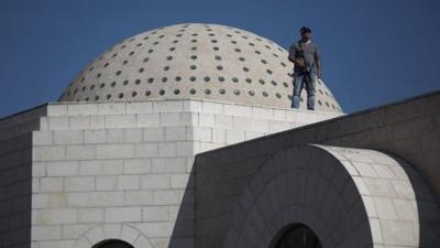 Police stand guard on a roof of synagogue