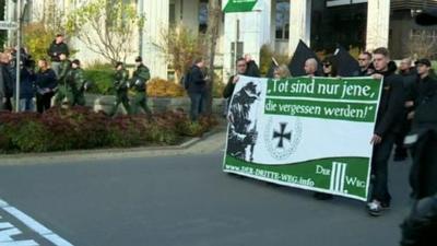 Neo-Nazis marching and carrying a banner