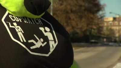 A soft toy, left in memorial of Michael Brown, wearing a t-shirt with the slogan 'copwatch'