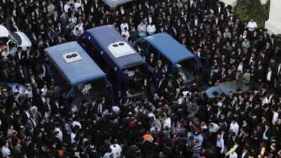 Ultra-Orthodox Jews mourn three of the victims of an attack on a Jerusalem synagogue