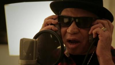 West African musician Salif Keita singing into microphone