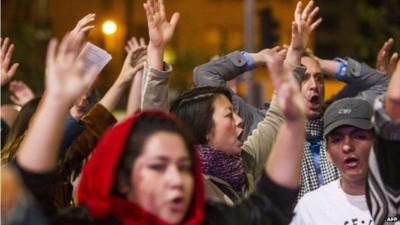 Demonstrators raise their hands and shout "hands up, don't shoot"