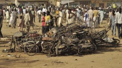 People at the site of a bomb explosion in Kano