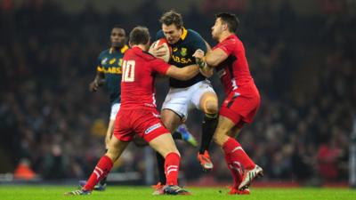 Wales players Dan Biggar and Rhys Webb tackle Jean de Villiers of South Africa during the Autumn international match between Wales and South Africa