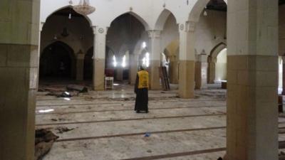 A mosque official surveys damage in the central mosque in northern Nigeria"s largest city of Kano on November 29, 2014