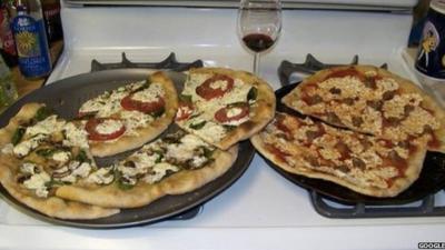 Two pizzas sitting on top of a stove top oven