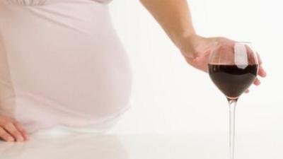 Pregnant woman with a glass of wine