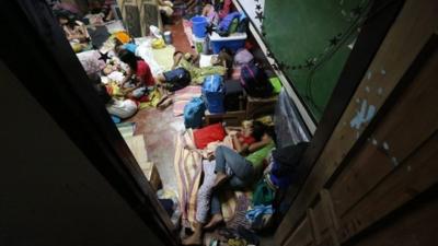 Filipino residents rest inside a school classroom turned into a temporary evacuation center in Tacloban city