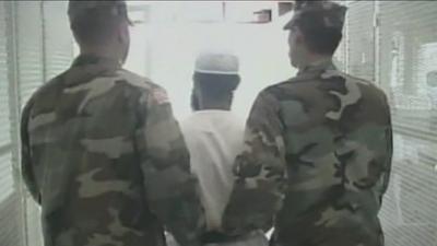 A prisoner being led away by two guards