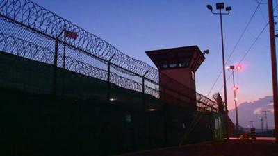 A barbed wire fence and a watch tower