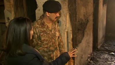 Pakistan army officer showing BBC reporter Mishal Hussain a burned out room in the Peshawar school attacked by the Taliban