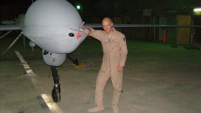 Brandon Bryant stood next to the drone he operated