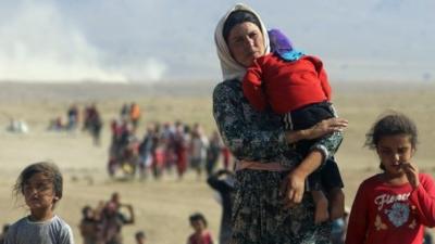 Displaced people from the Yazidi religious minority walk from Mount Sinjar towards the Syrian border (11 August 2014)