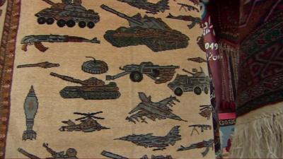 Afghan rug covered in military vehicles