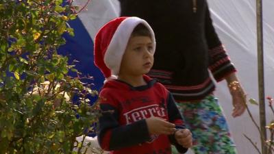 A young Iraqi boy wearing a Santa hat