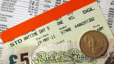 Train ticket, money and a railway timetable