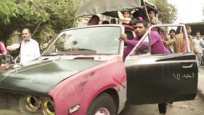 People push shabby old car