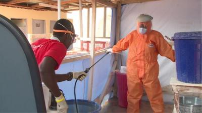 An Ebola healthcare worker being decontaminated