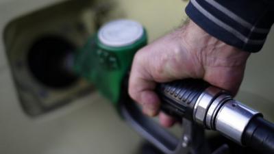 A man fills up his car at a petrol station