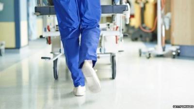 An A&E doctor pushing a trolly down a corridor