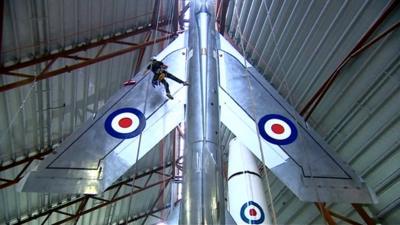 Man on a rope cleaning a plane