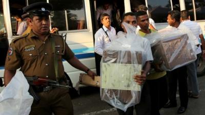 Sealed ballot boxes carried from polling station