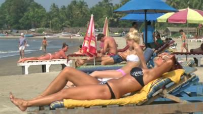 Sunbathing on beach in Goa