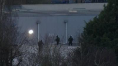 Figures on the warehouse roof