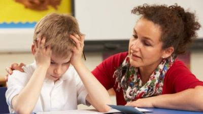 Teacher helps pupil with schoolwork