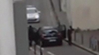 The Kouachi brothers aiming their guns at a police car