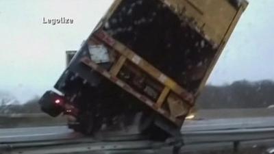 Close-up of tractor-trailer tipping over as it jack-knifes across New Jersey Interstate