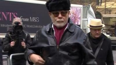 Paul Gadd aka Gary Glitter arrives at court (black hat)