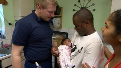 First responder Mike Hardy with Joaquim and Patricia Rodrigues and baby