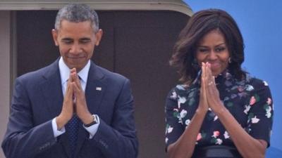 President Barack Obama and first lady Michelle Obama fold their hands together in a traditional Indian greeting gesture as they prepare to board Air Force One in New Delhi, India, Tuesday, Jan. 27, 2015