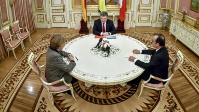 Ukrainian President Petro Poroshenko (top), German Chancellor Angela Merkel (L) and French President Francois Hollande during their talks in Kiev on February 5, 2015