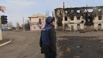 BBC reporter James Reynolds in front of a burned out building inside the rebel-held town of Vuhlehirsk in Ukraine