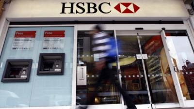 A pedestrian passes a branch of HSBC bank in London