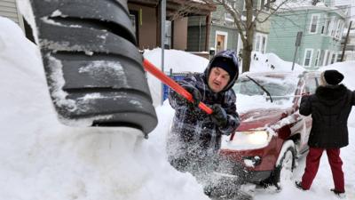 Rich and Kathy Melvin shovel out their car in front of their house in Somerville, Mass.