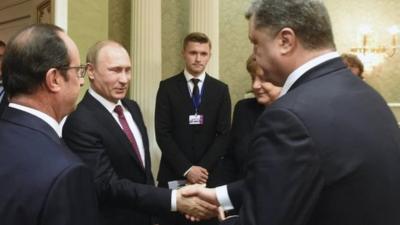 Russian President Vladimir Putin (smiling) shakes hands with Petro Poroshenko in Minsk, 11 February