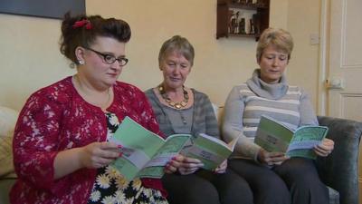 three women holding their book