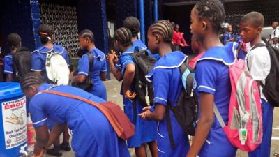 Students wash hands before entering school in Liberia