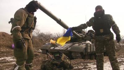 Rebels in front of a tank