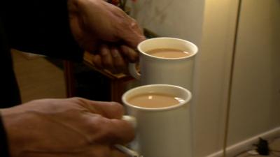 'Dementia friend' carries two cups of tea