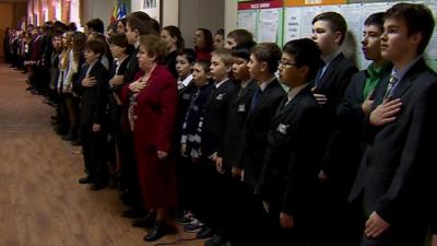 Mariupol high school students sing the national anthem of Ukraine