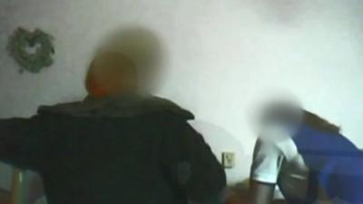 Two care workers leaning over a bed