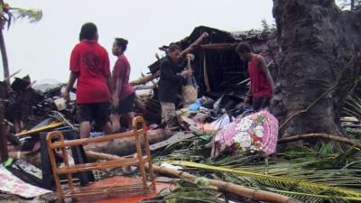 Local residents look through the remains of a small shelter in Port Vila, the capital city of the Pacific island nation of Vanuatu March 14, 2015