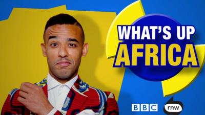 Satirist Ikenna Azuike in front of 'What's up Africa' logo